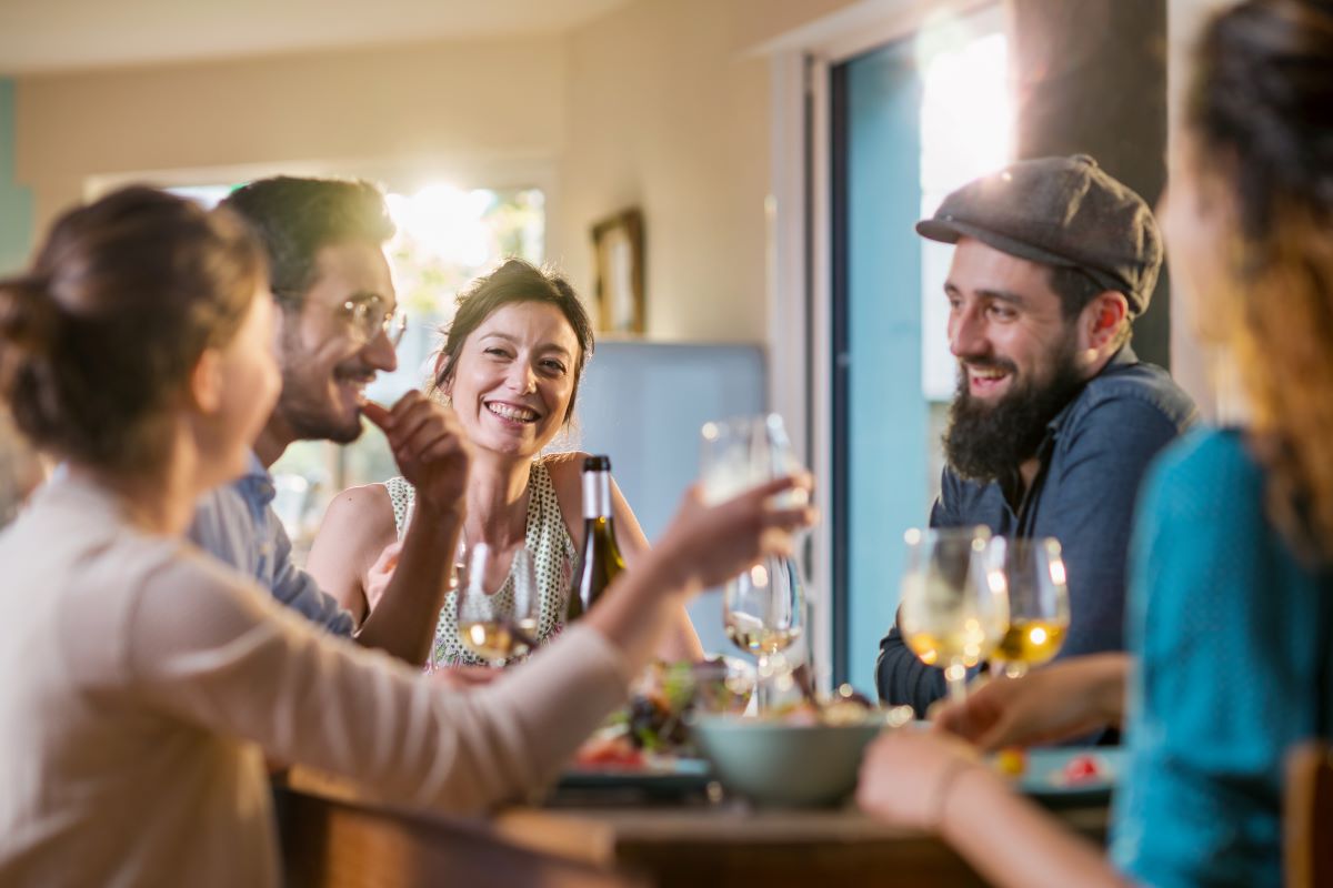 A group of friends laugh together over a meal.