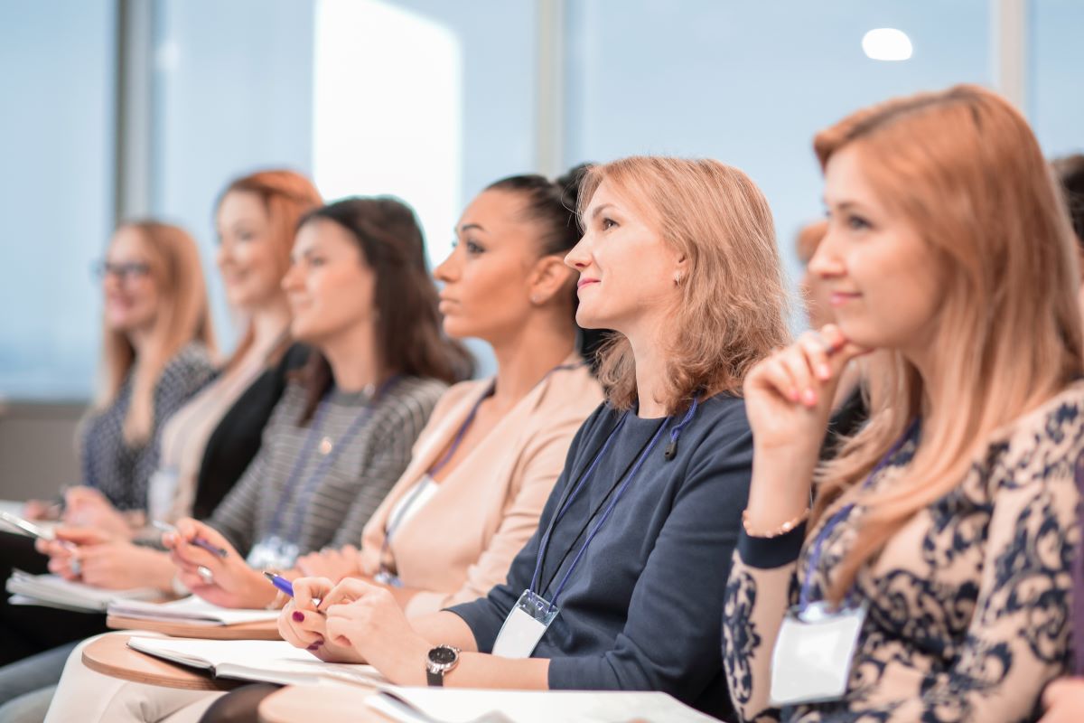 Women in the office listen to someone speak