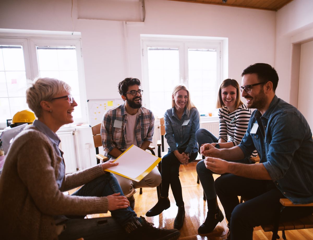 A group of happy coworkers converse together.