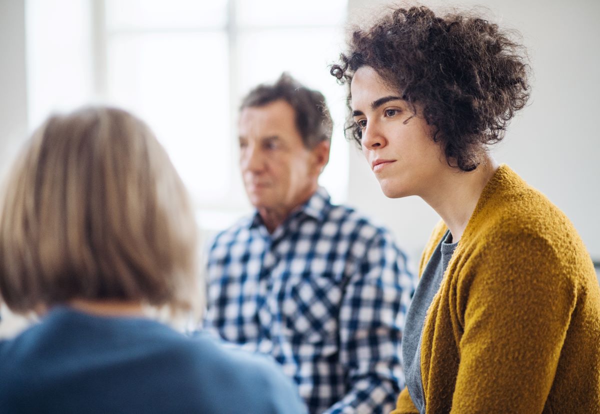 A woman listens in a group setting