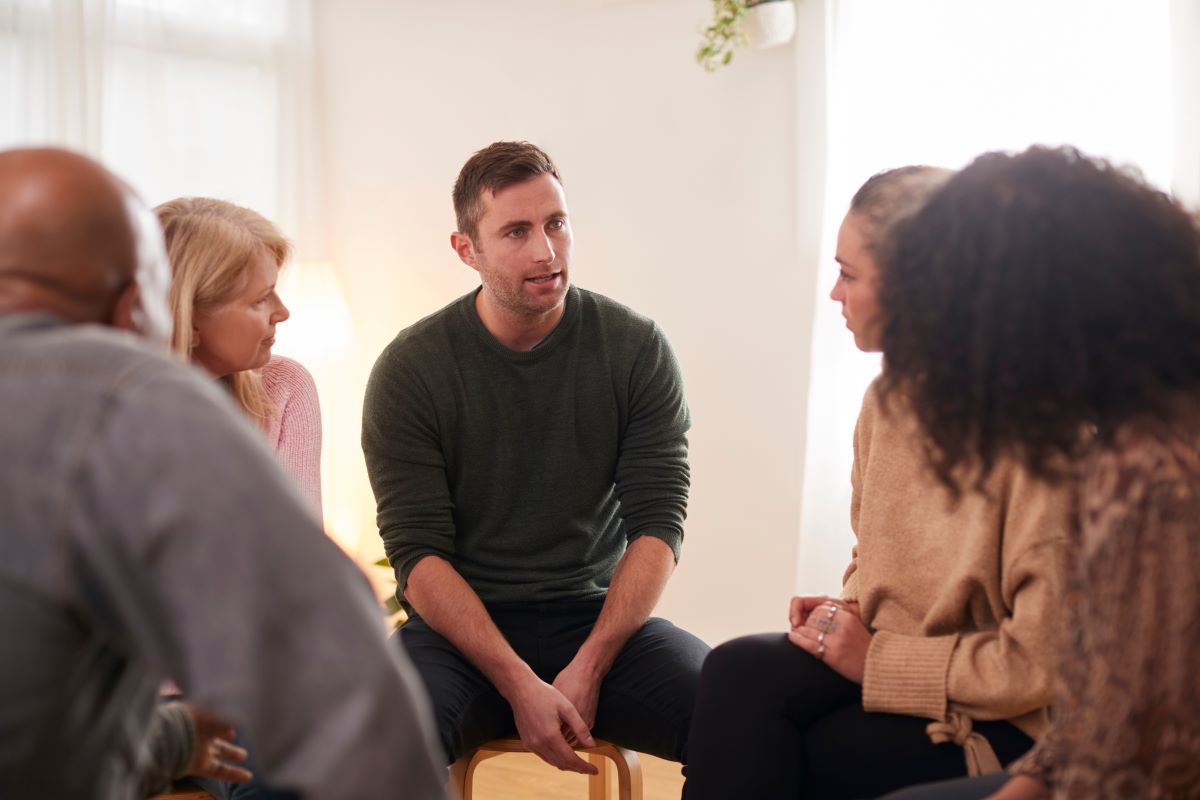 A man in a group counselling setting.