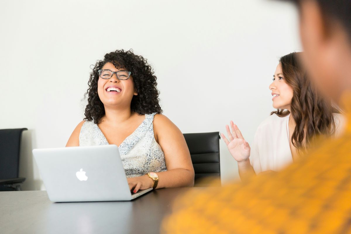 Smiling woman with laptop at a work meeting