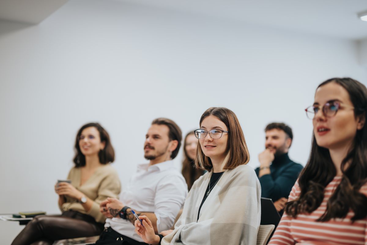 A group of professionals listen to a presentation.