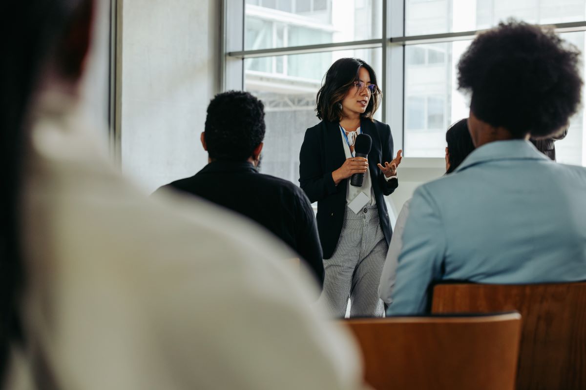 A woman presents to a room of office workers.