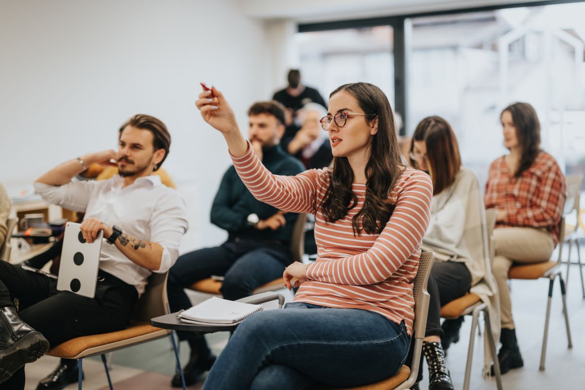 A woman raises a point in a work meeting