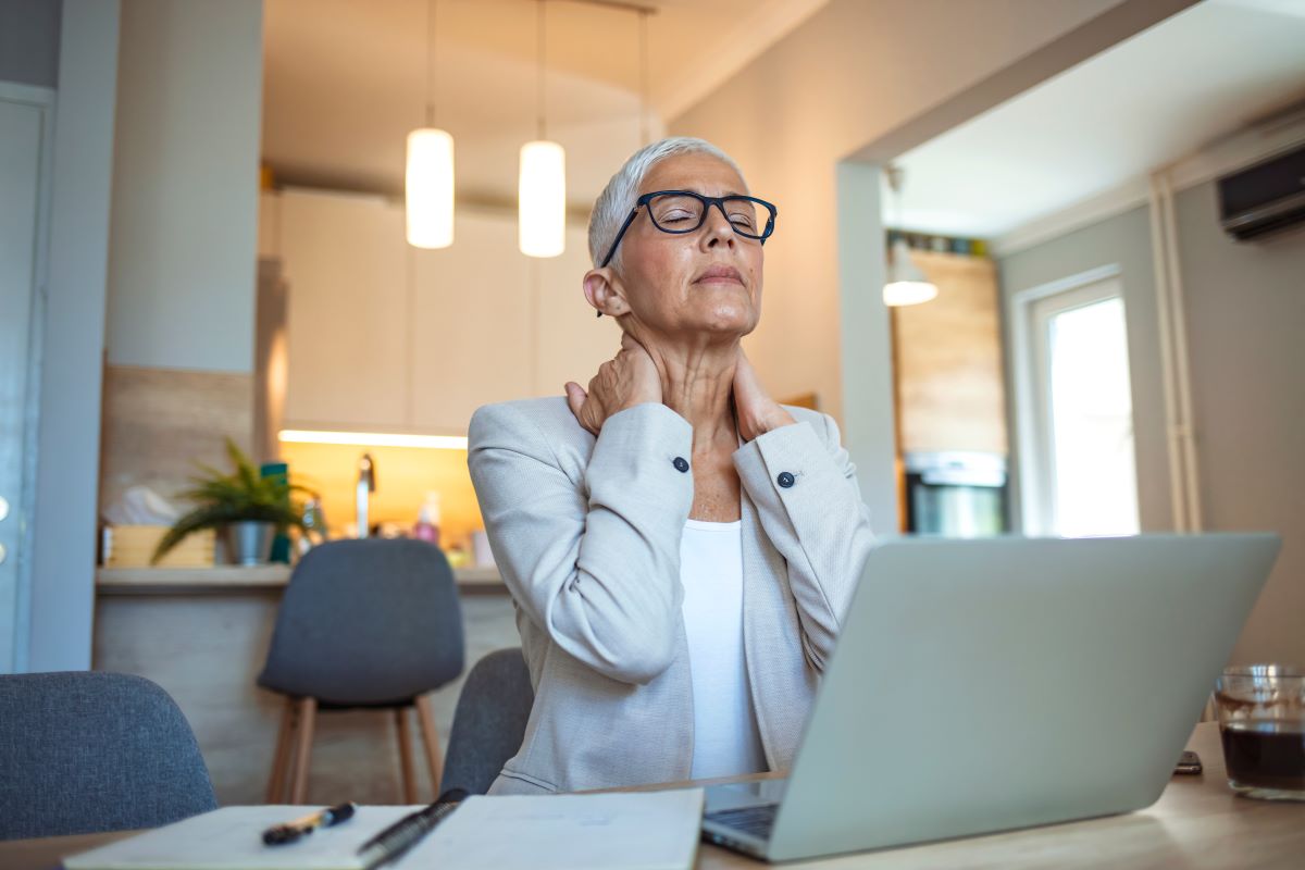 A woman at work struggles with menopause symptoms.
