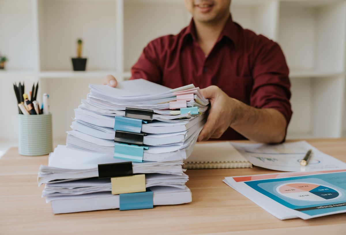 A man deals with a stack of paperwork.