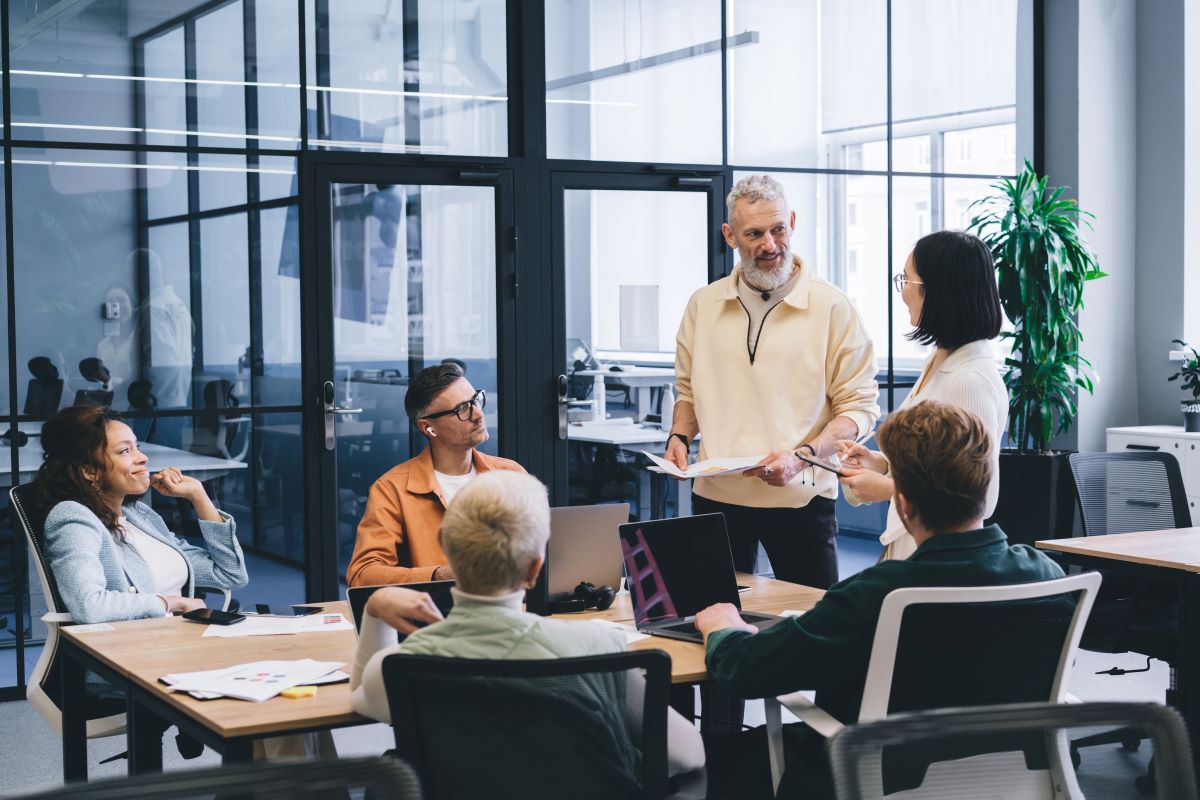 A small team discuss ideas in a meeting room.