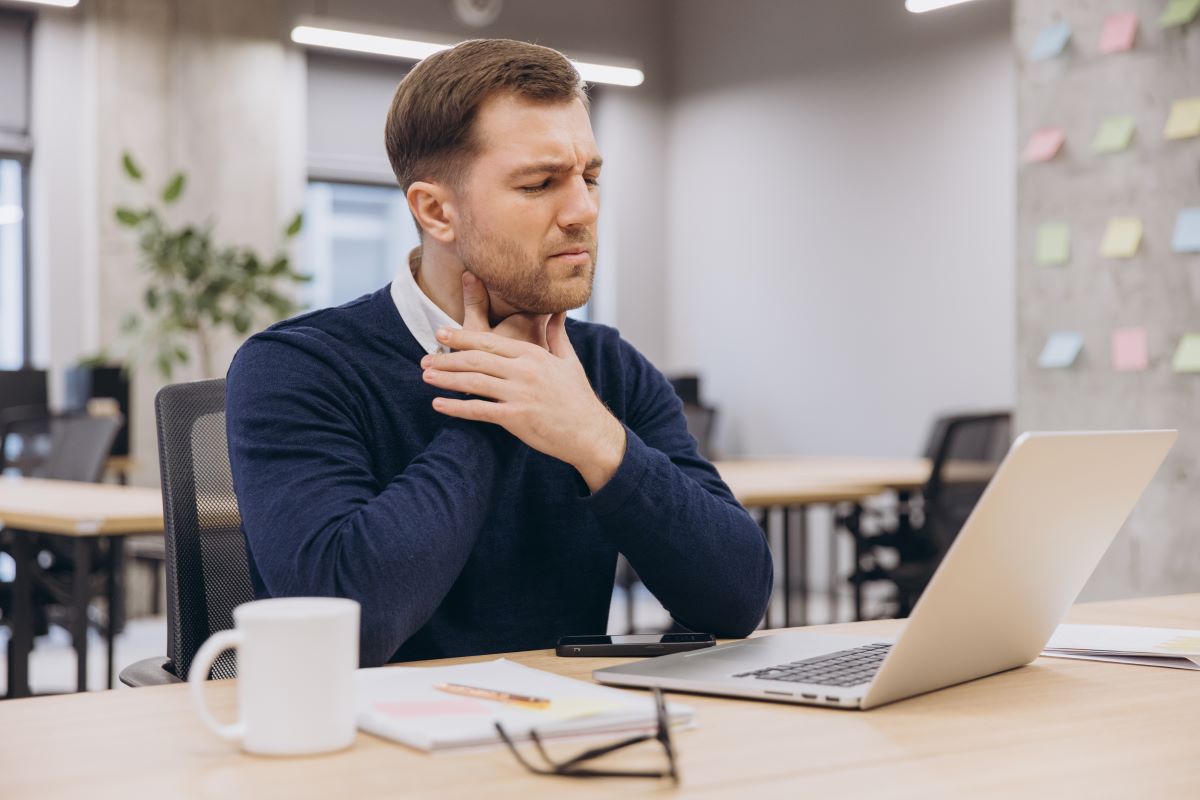 A man at work has a sore throat.