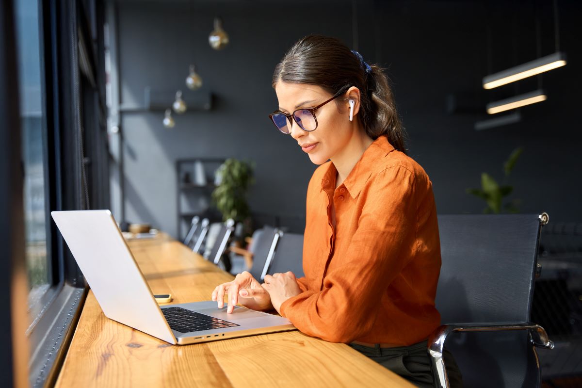 A professional woman sits at her work laptop.